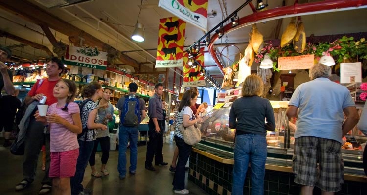 Crowds fill an indoor market to shop for meats.