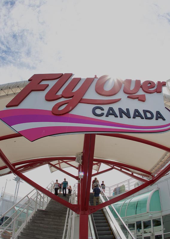 A stairway and escalator lead up to FlyOver Canada