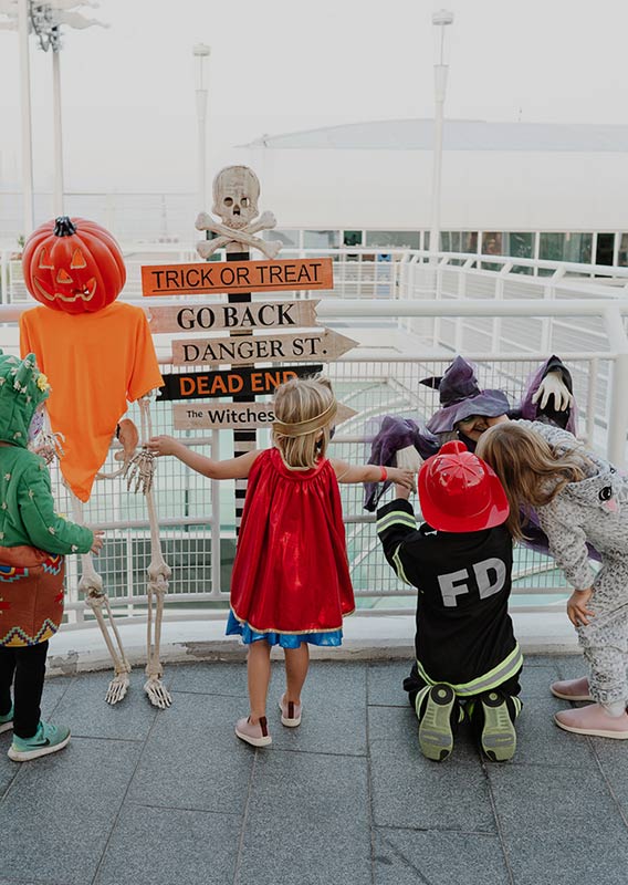 A group of kids in Hallowe'en costumes with decorations.