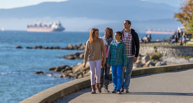 A family walks along the sea shore.