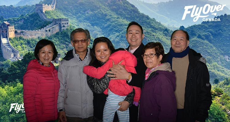 A family photo in front of a Great Wall of China backdrop
