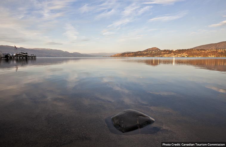 A panoramic view of a long lake between rolling hills on either side