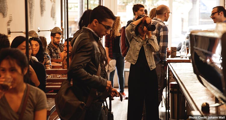 A group of people milling about a cafe