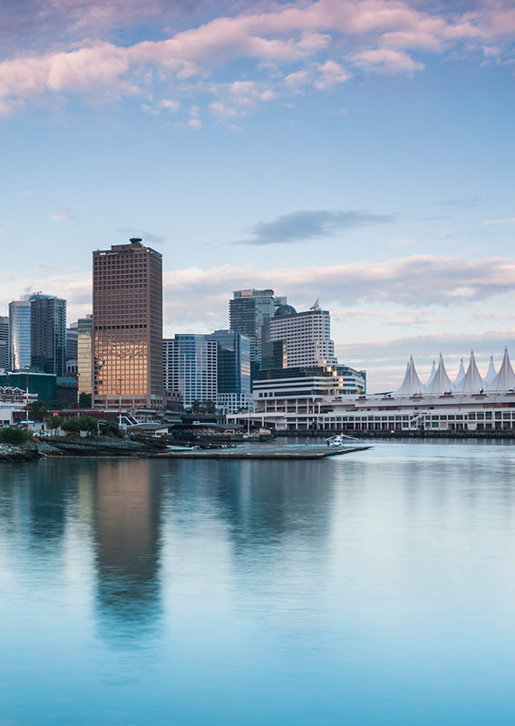 Vancouver skyline over water with high rise buildings and pink clouds