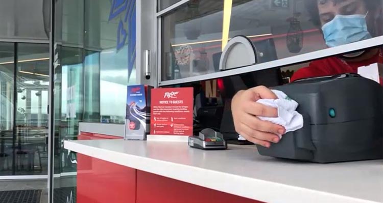 A worker cleans a ticket reading machine.