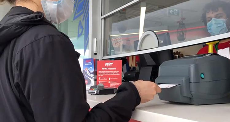 A person inserts a ticket into an electronic ticket reader.