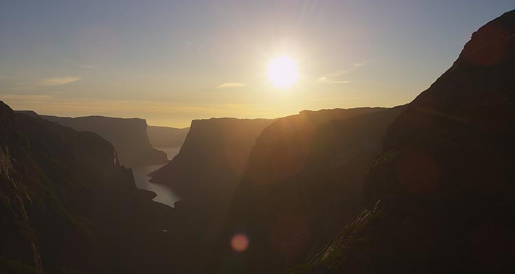 A view down a narrow fjord with tall cliffsides.