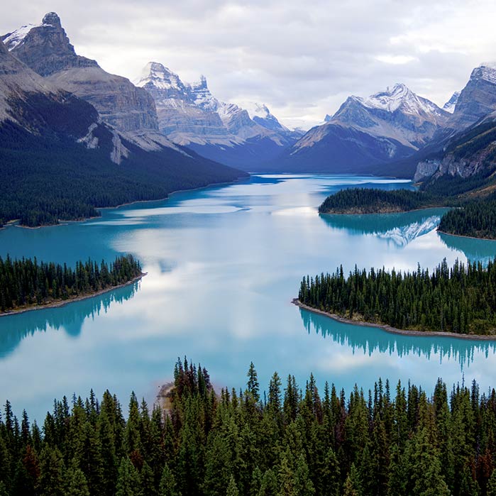 An aerial view of a lake between tall mountains.