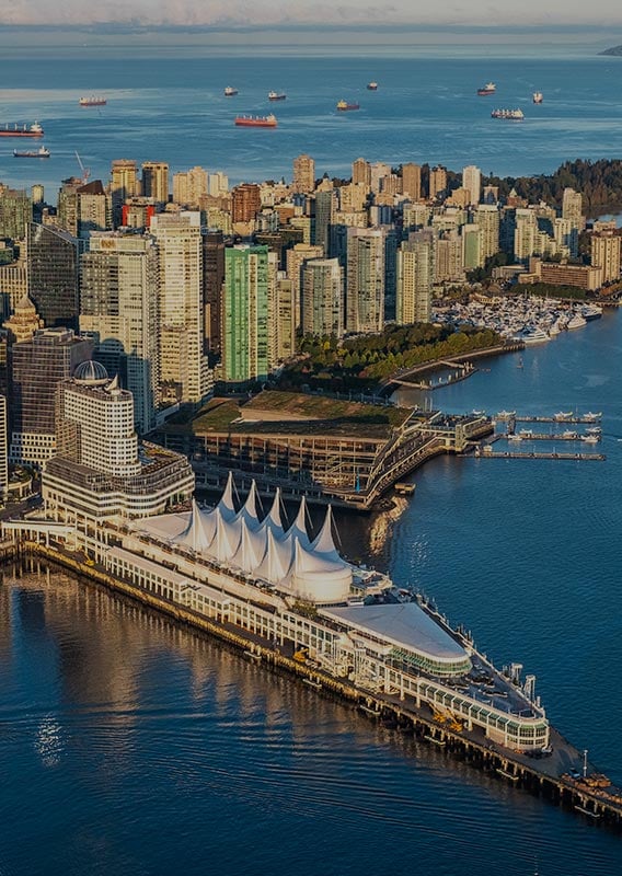 An aerial view of downtown Vancouver, with the sea on both sides of the city.