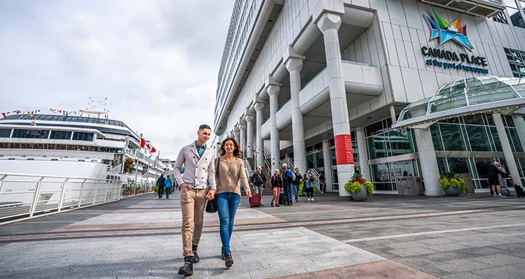 Couple walking alongside Canada Place.